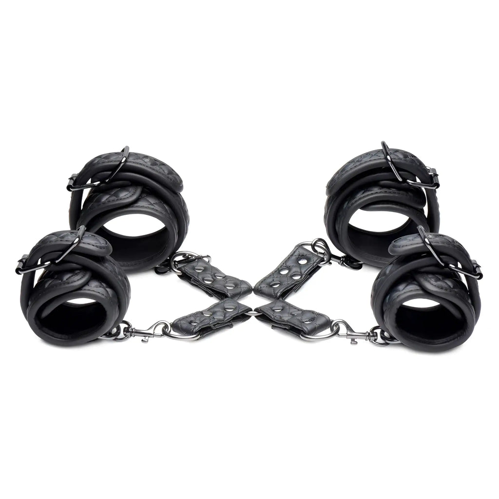 Master Series Concede black quilted leather wrist and ankle restraints with metal hardware and hog-tie adaptor.