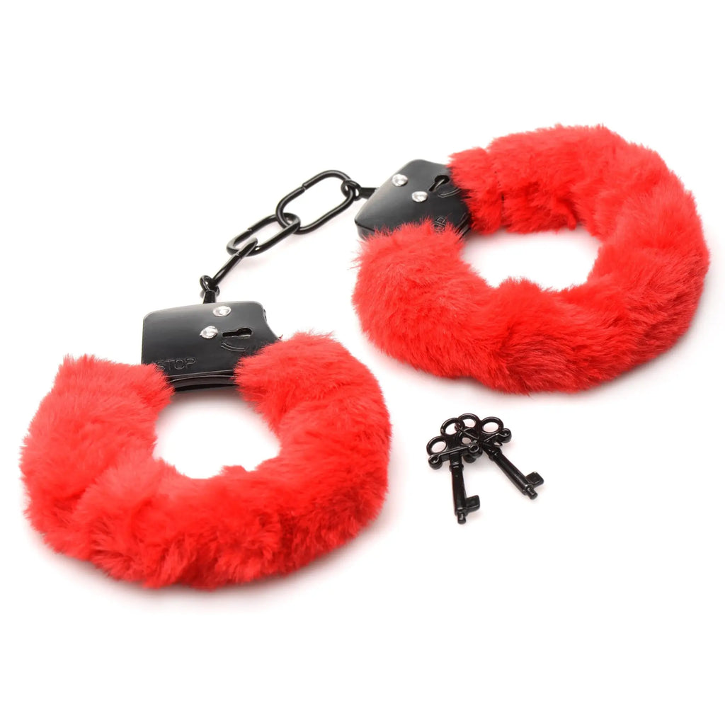 Master Series Cuffed In Fur handcuffs in bright red, featuring black metal hardware and matching black keys.
