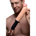 A man holds a fleshy, realistic-textured Master Series Curved Dicktator thruster with a black, ribbed ergonomic handle.