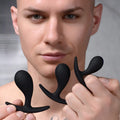 A person holding three black, curved, matte silicone Master Series Dark Droplets anal trainers of varying sizes.