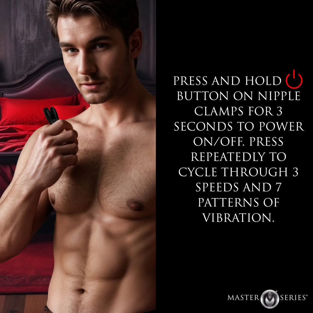 A shirtless man holds black Master Series Dark Grip vibrating nipple clamps in front of a red-themed bedroom background.
