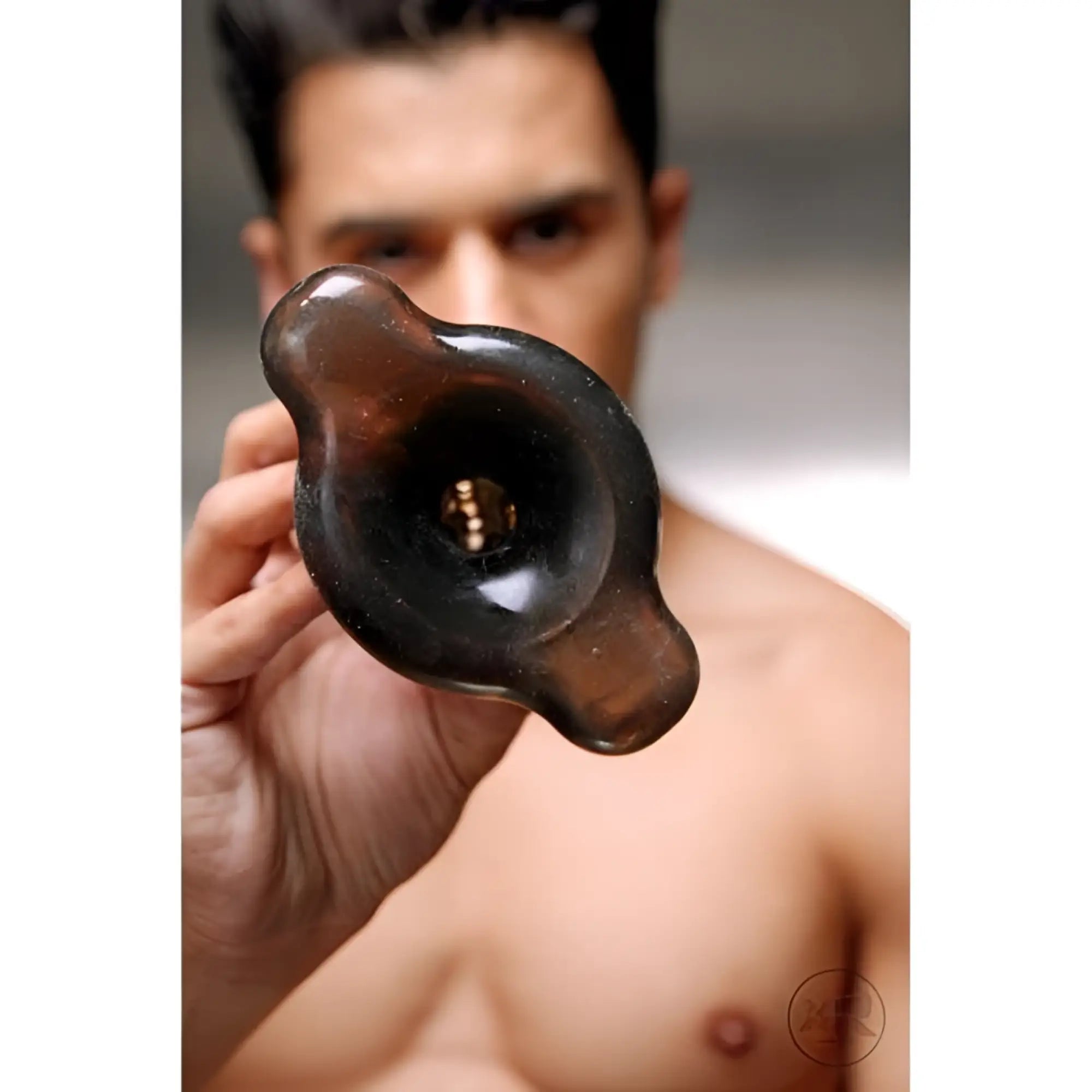 Close-up of a hand holding a translucent black Master Series Dark Inception device with a flared base.