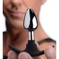 Master Series Dark Invader anal plug with a polished silver metal tip and black silicone T-shaped handle.
