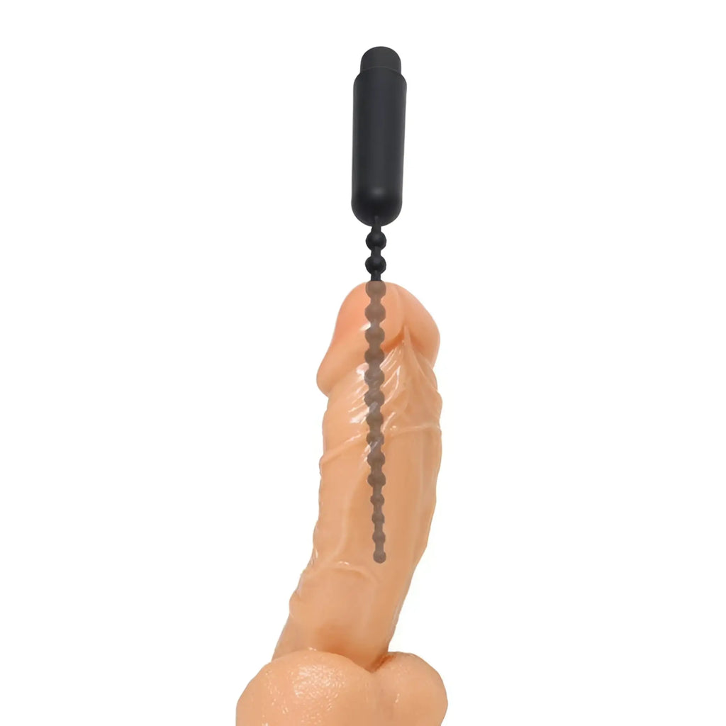Master Series Dark Rod vibrating beaded silicone sound inserted into a realistic flesh-toned penis model on white background.