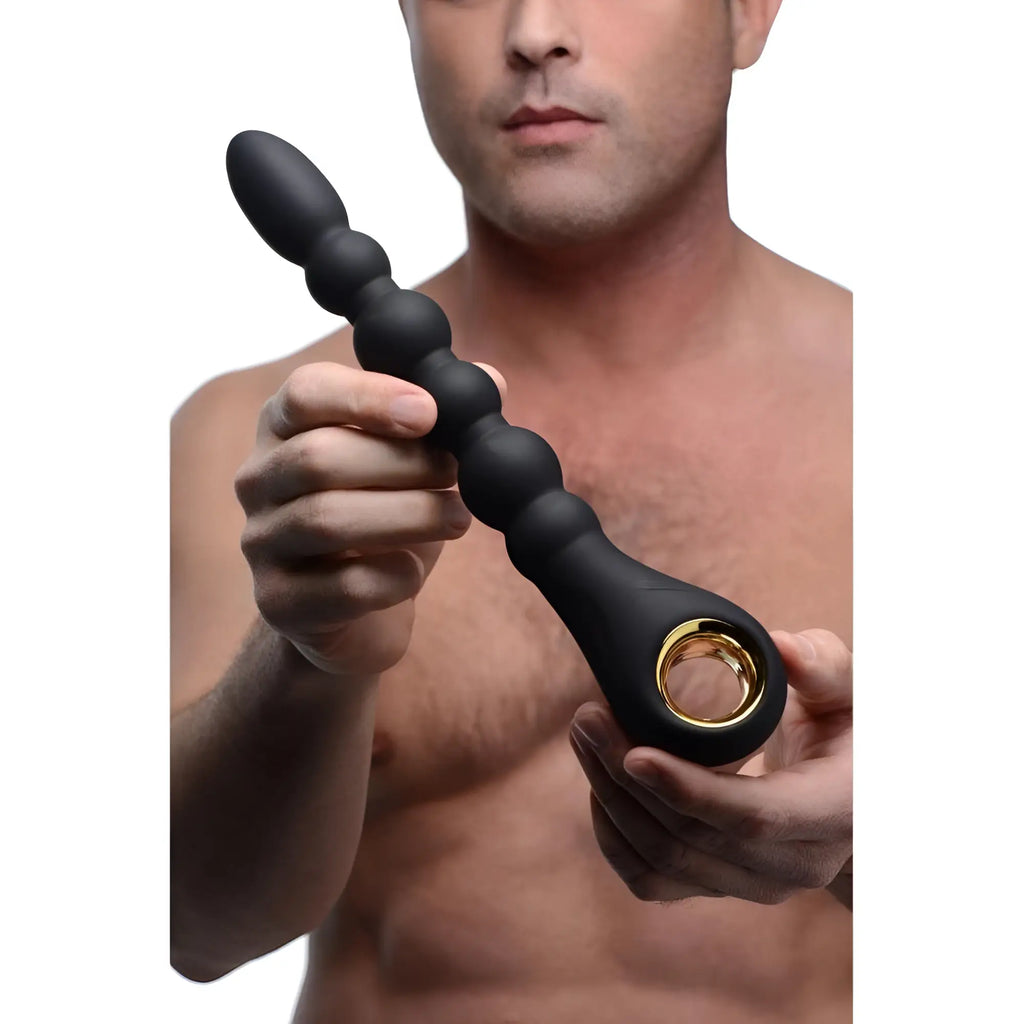 A man holding the matte black, 10-bead Master Series Dark Scepter with a gold-accented ring base.