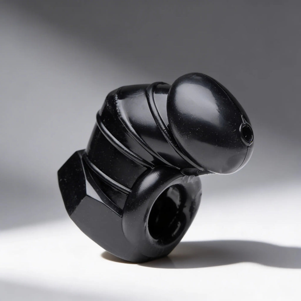 Master Series Detained: A glossy black, restrictive chastity cage featuring a secure ring and vented, anatomical design.