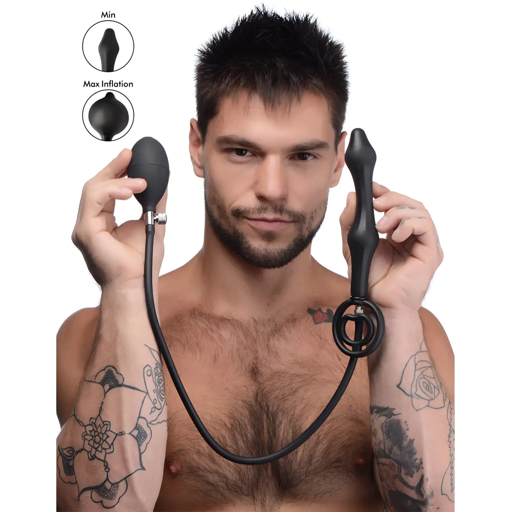 A man holds the black silicone Master Series Devils Rattle inflatable anal plug with a ball pump and ring.