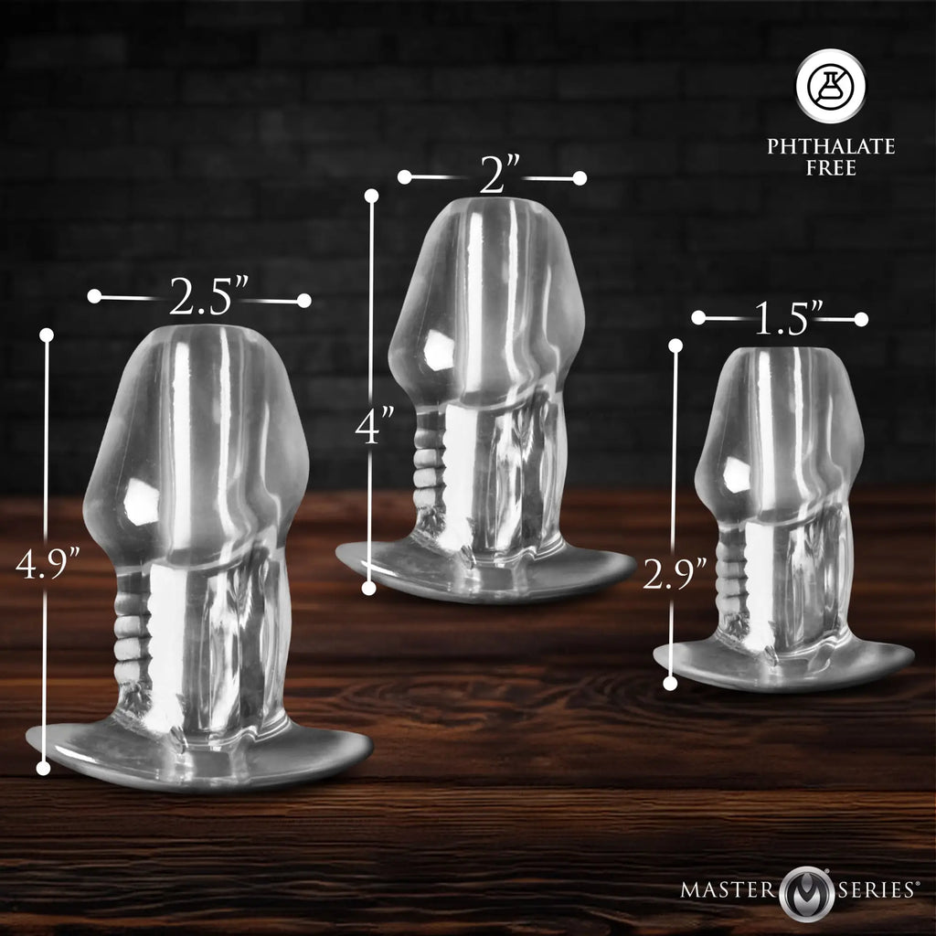 Master Series 3pc clear hollow anal plug set, phallic-shaped with measurements shown on a wood surface.