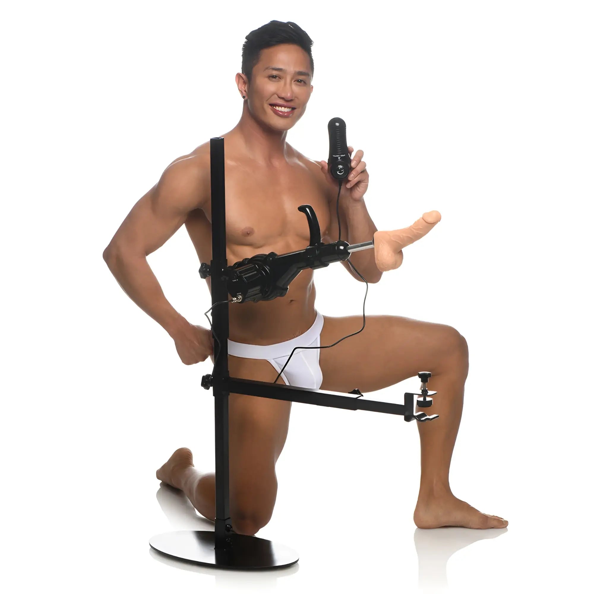 A man in white underwear poses with the black Master Series The Dicktator 2.0 machine, featuring a realistic attachment.