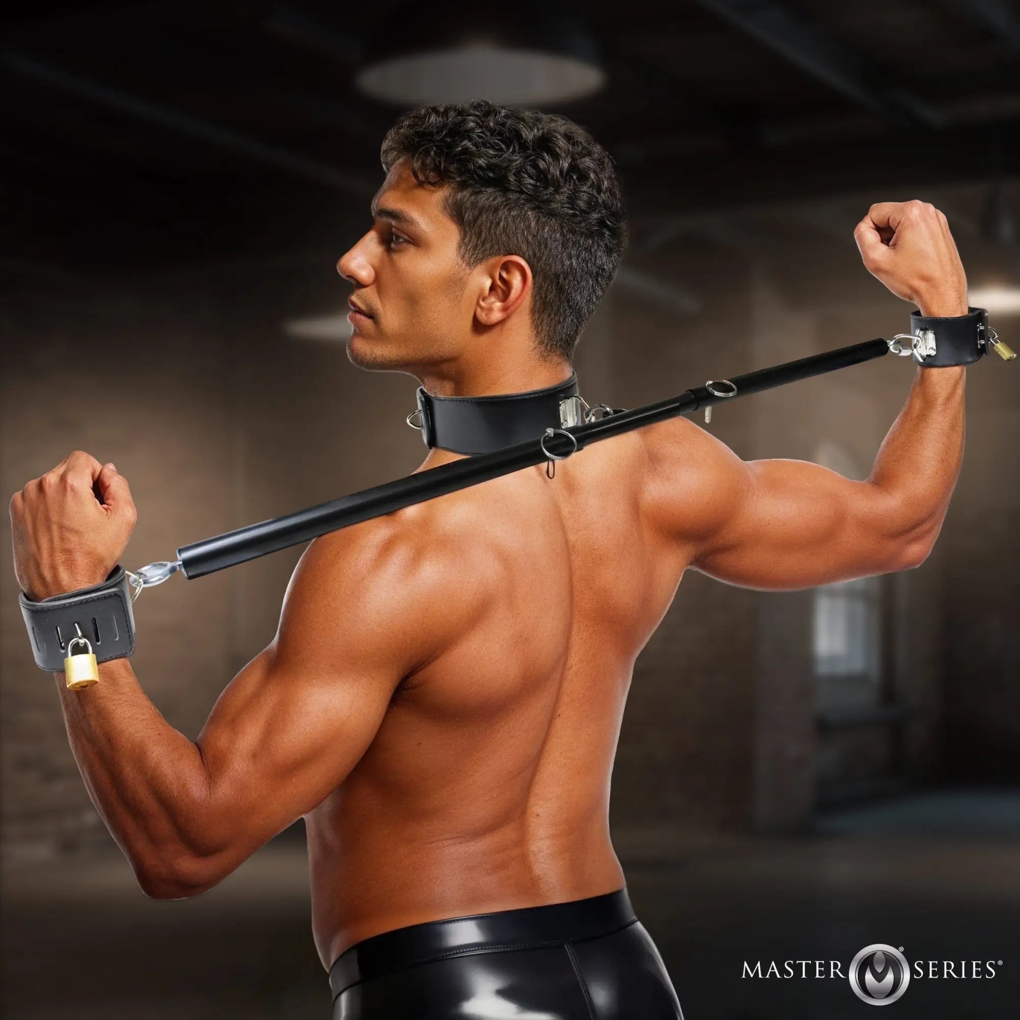 Master Series Dominion black leather spreader bar with collar and locking wrist restraints worn by a shirtless man.