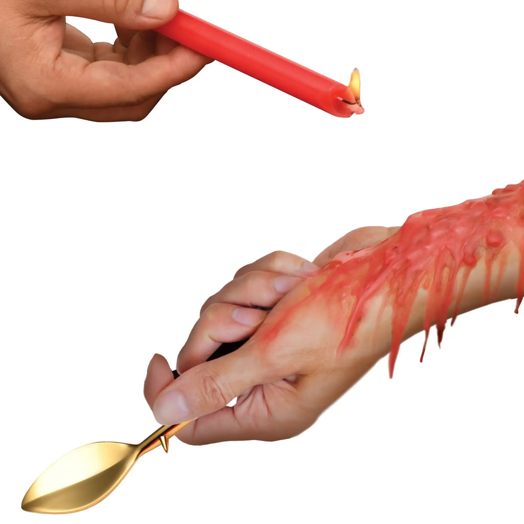 Master Series Drip Sensation: a lit red waxplay candle dripping onto an arm, shown with a gold-tone scraping tool.