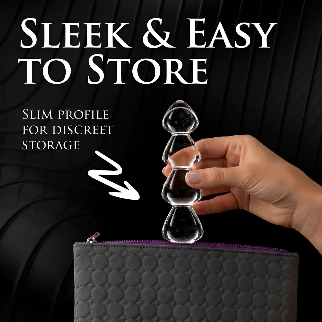 Master Series Drops Anal Link: A clear, glass, multi-bead dildo being placed into a gray, zippered storage pouch.