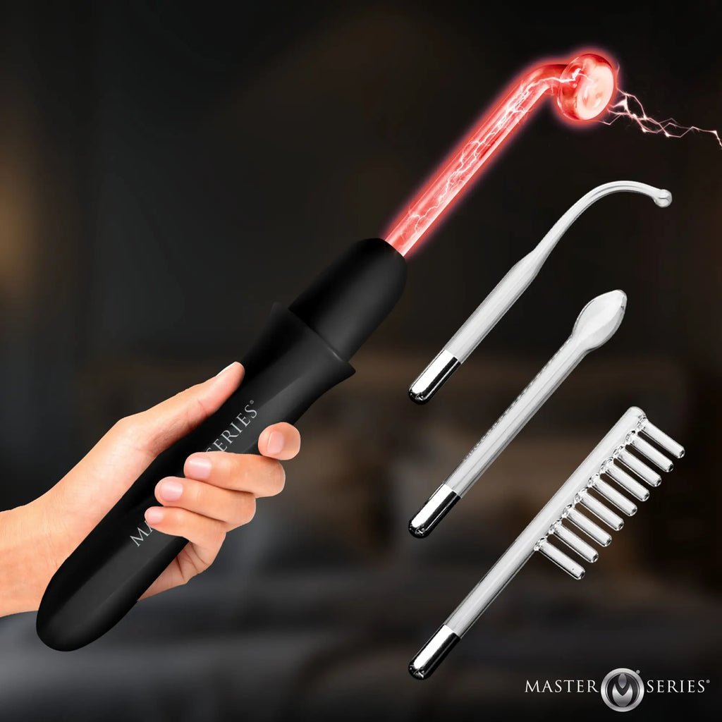 Hand holding a black Master Series Elektrawand with a glowing red glass electrode and three clear glass attachments.