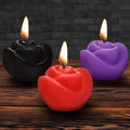 Master Series Fire Garden 3pc rose-shaped candle set in black, red, and purple, each with a lit flame on wood surface.