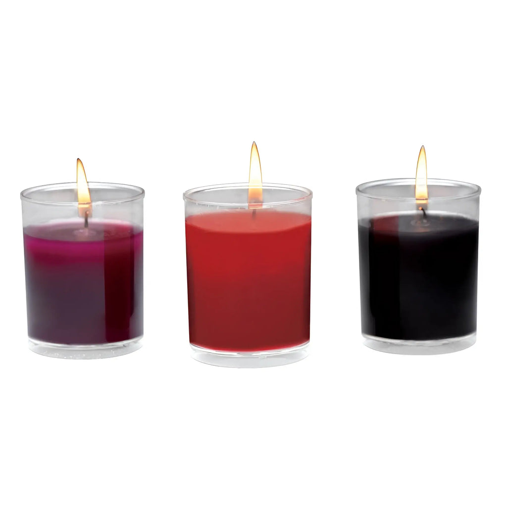 Master Series Flame Drippers wax play candle set with three burning candles in purple, red, and black glass holders.