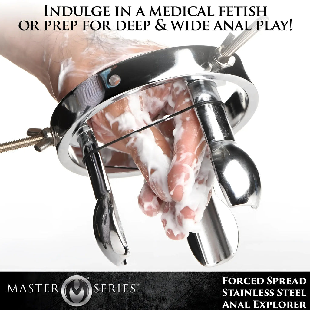 Master Series Forced Spread Stainless Steel Anal Explorer: A silver metal tool with three prongs around a hand in lube.