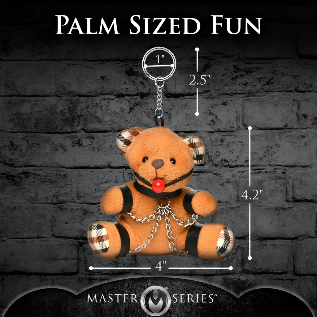 Master Series Gagged Teddy Bear Keychain with plaid accents, black leather bondage gear, red ball gag, and metal chains.