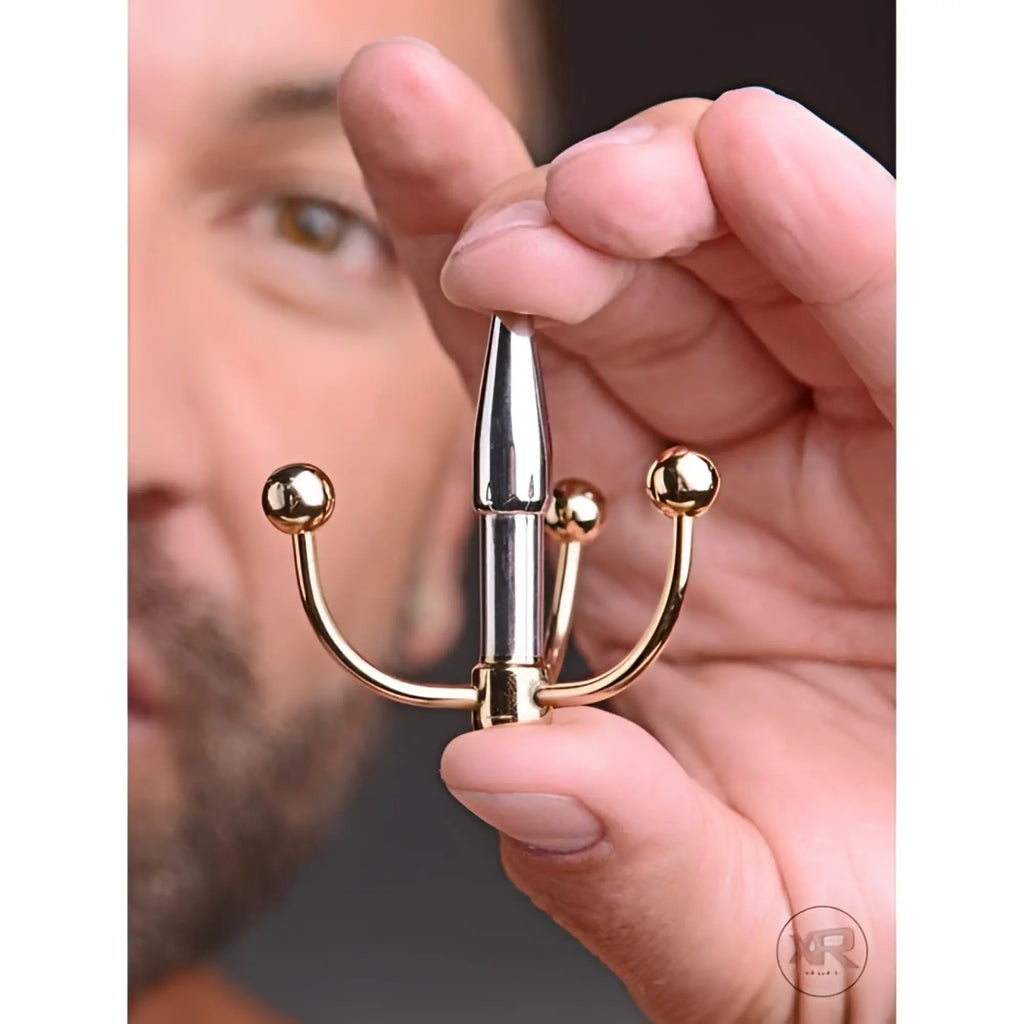 Master Series Golden Claw Urethral Plug: a metallic silver, tapered plug with three curved, golden ball-tipped arms.