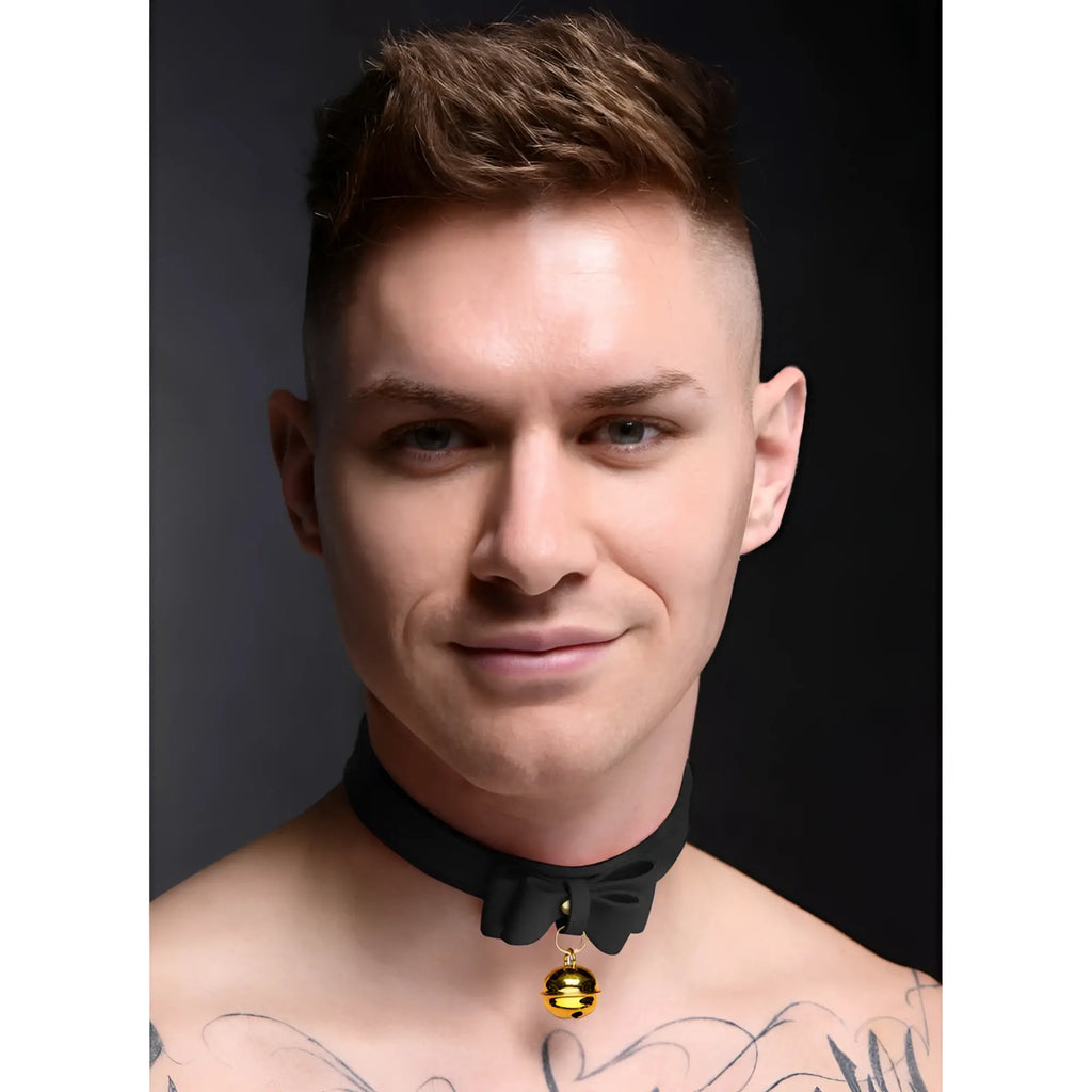 A man wearing a black Master Series Golden Kitty Cat Bell Collar with a black bow and a gold bell.