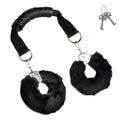 Master Series The Handler: black furry handcuffs attached by straps to a central black handle, with two keys.