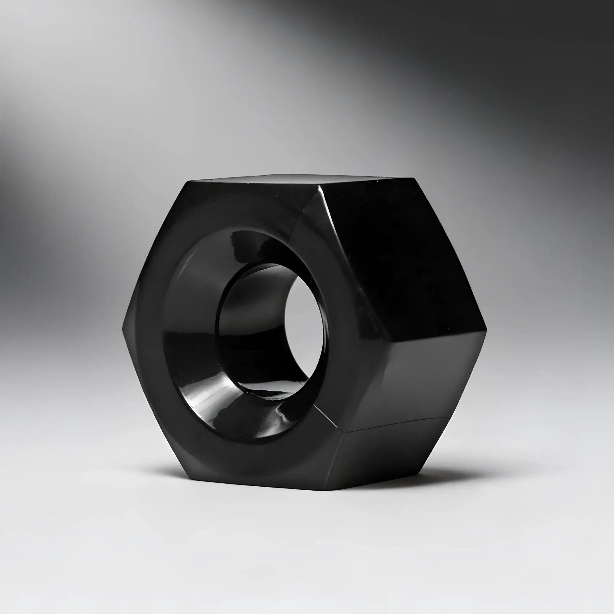 Master Series Hex heavy-duty cock ring and ball stretcher in a glossy, black, hexagonal nut design.