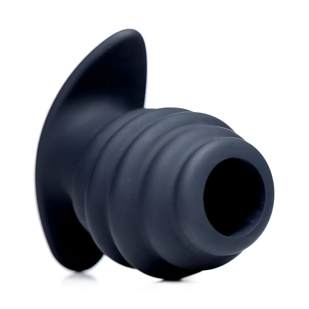 Master Series Hive Ass Tunnel: A black, ribbed silicone hollow anal plug with a wide, flared base.