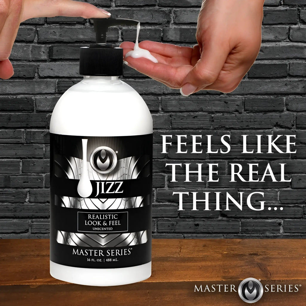 A hand pumps white Master Series Jizz Unscented Lube from a black-and-white 16 oz bottle against a brick background.