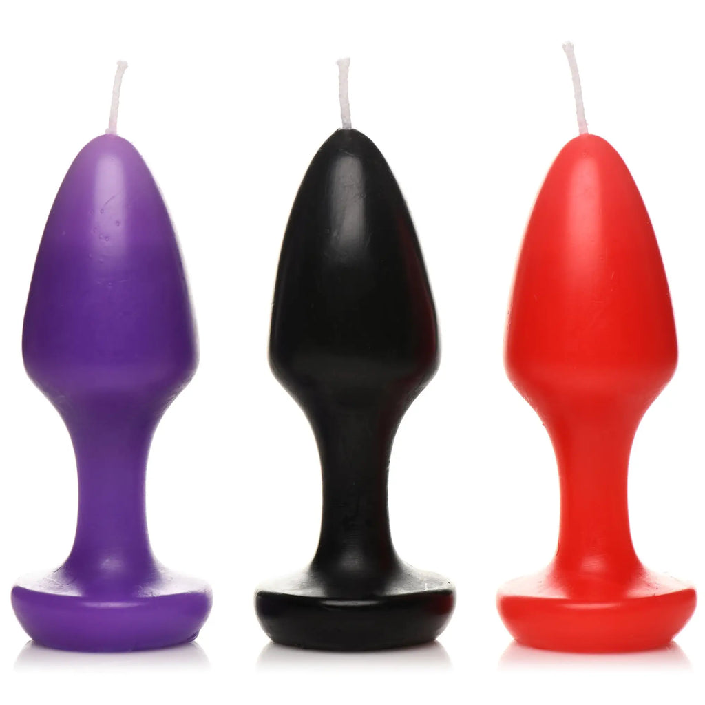 Master Series Kink Inferno Drip Candles: three plug-shaped candles in purple, black, and red with a single wick each.