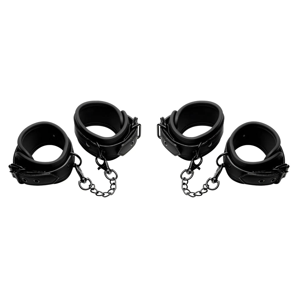 Master Series Kinky Comfort set: four black padded wrist and ankle cuffs connected by short metal chains.