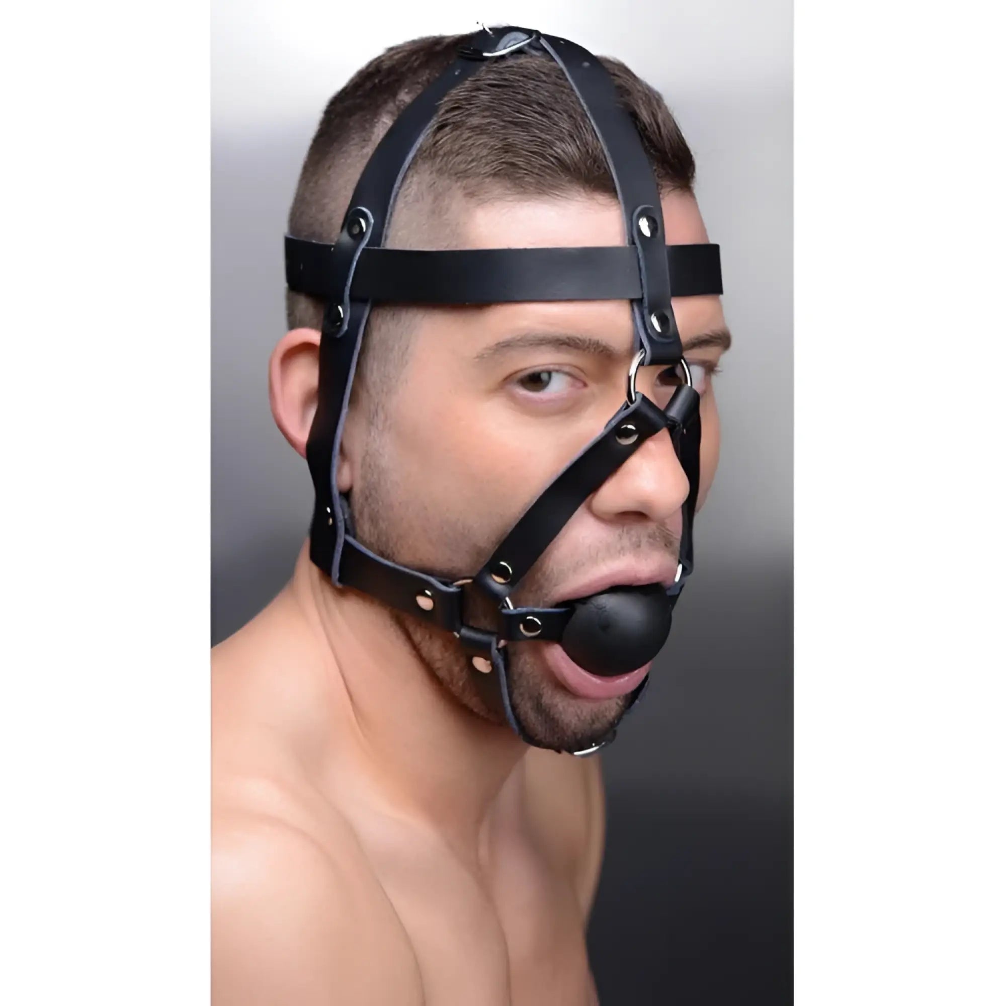 Master Series black leather head harness with silver-tone hardware and a black ball gag worn by a man.
