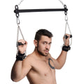 Master Series Levitate Suspension Bar: A shirtless man using a black metal bar with hanging chains and black cuffs.