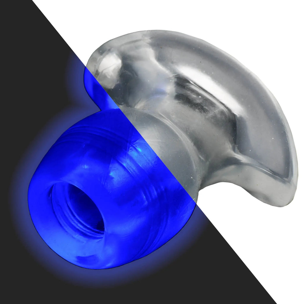 Master Series Light-Tunnel anal dilator: A clear, flared-base plug, partially illuminated with a vibrant blue LED light.