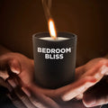 Master Series Lover's Vanilla Massage Candle in a matte black jar, held in hands, with a lit wick and soft glow.