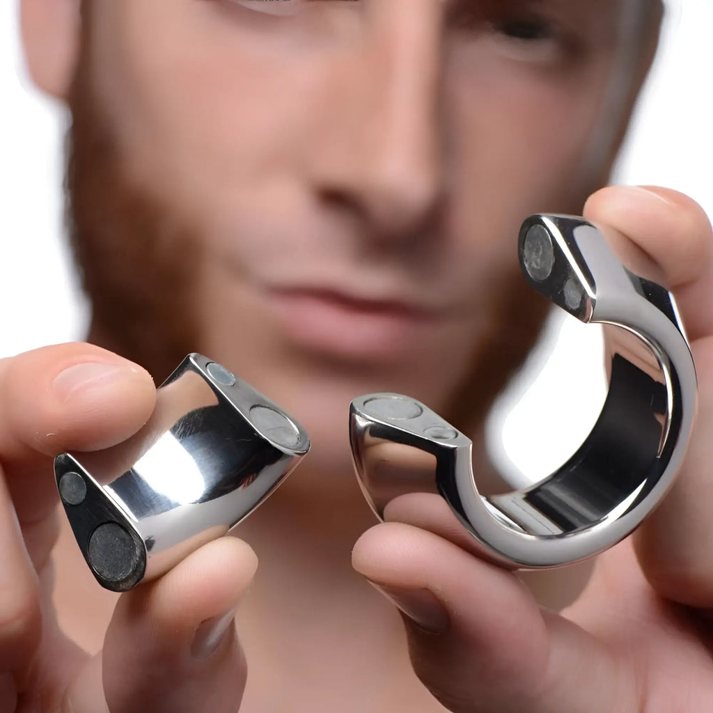 Master Series Magna-Chute: A person holding the two silver, C-shaped magnetic pieces of the ball stretcher.