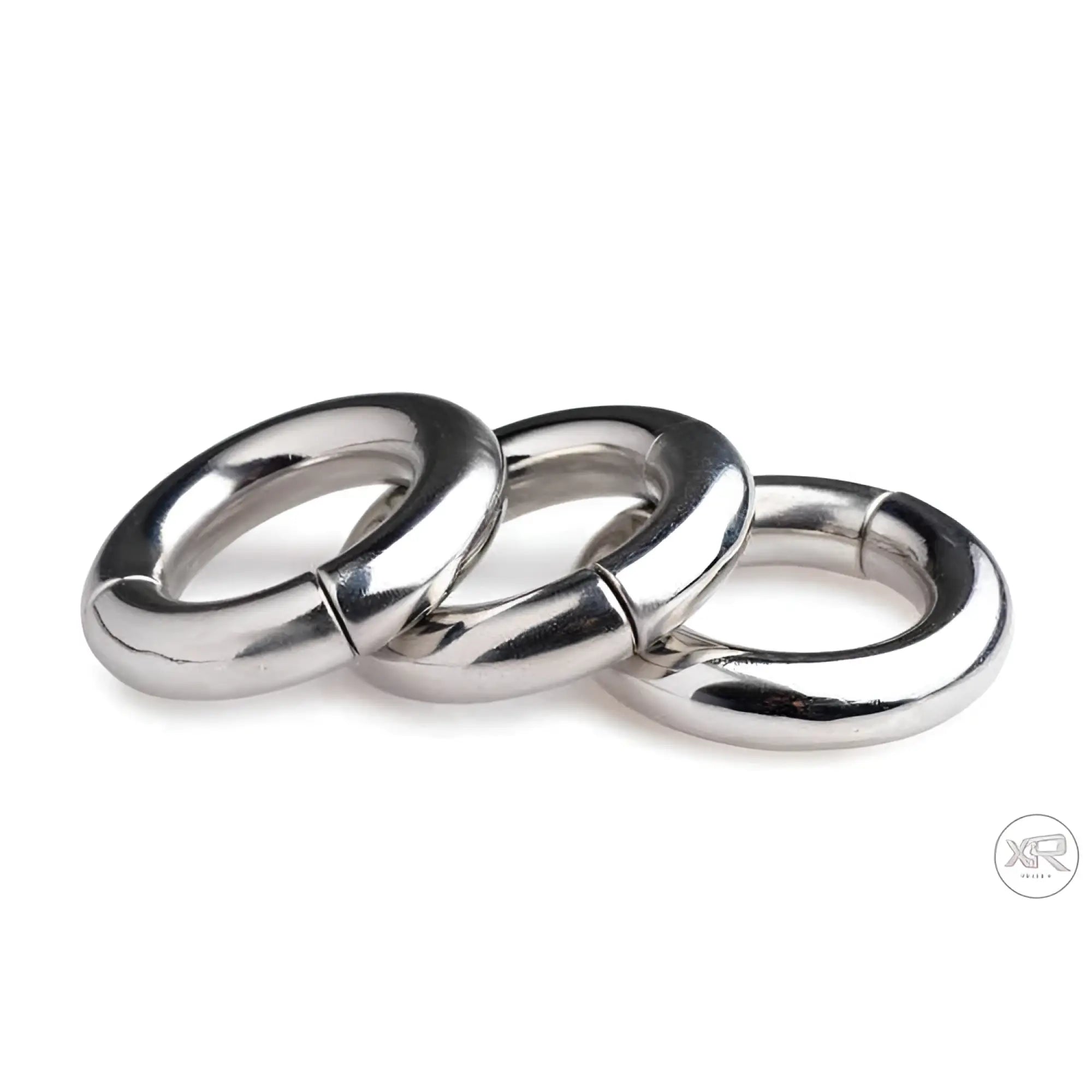 Master Series Magnetize: Three polished, silver-tone stainless steel magnetic ring stretchers arranged in a row.