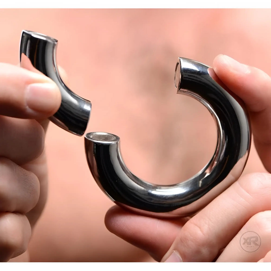 Master Series Magnetize: Hands hold a polished, silver stainless steel magnetic ball stretcher in two pieces.