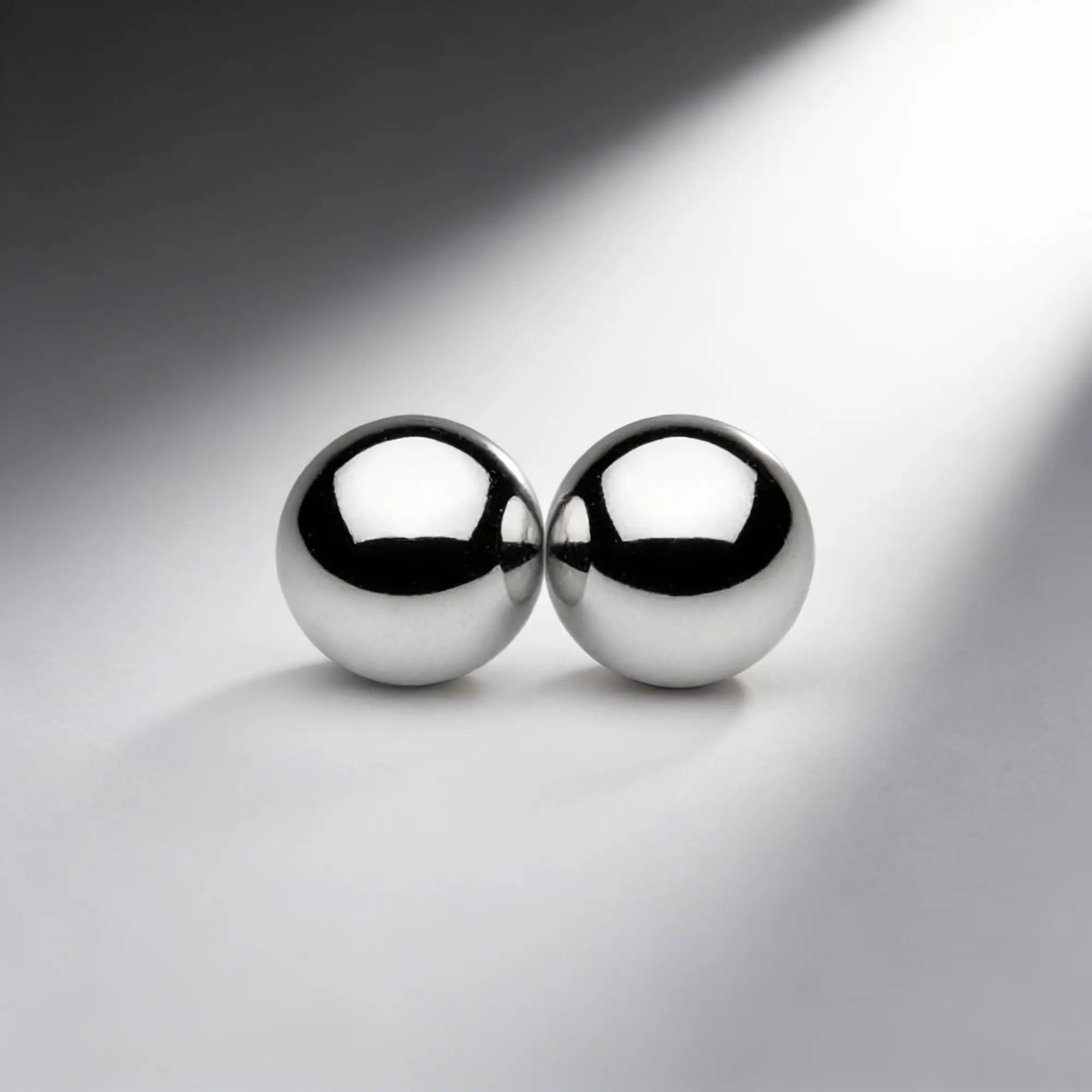 Two polished, chrome-colored Master Series Magnus Mighty Magnetic Orbs sitting side-by-side on a light gray surface.