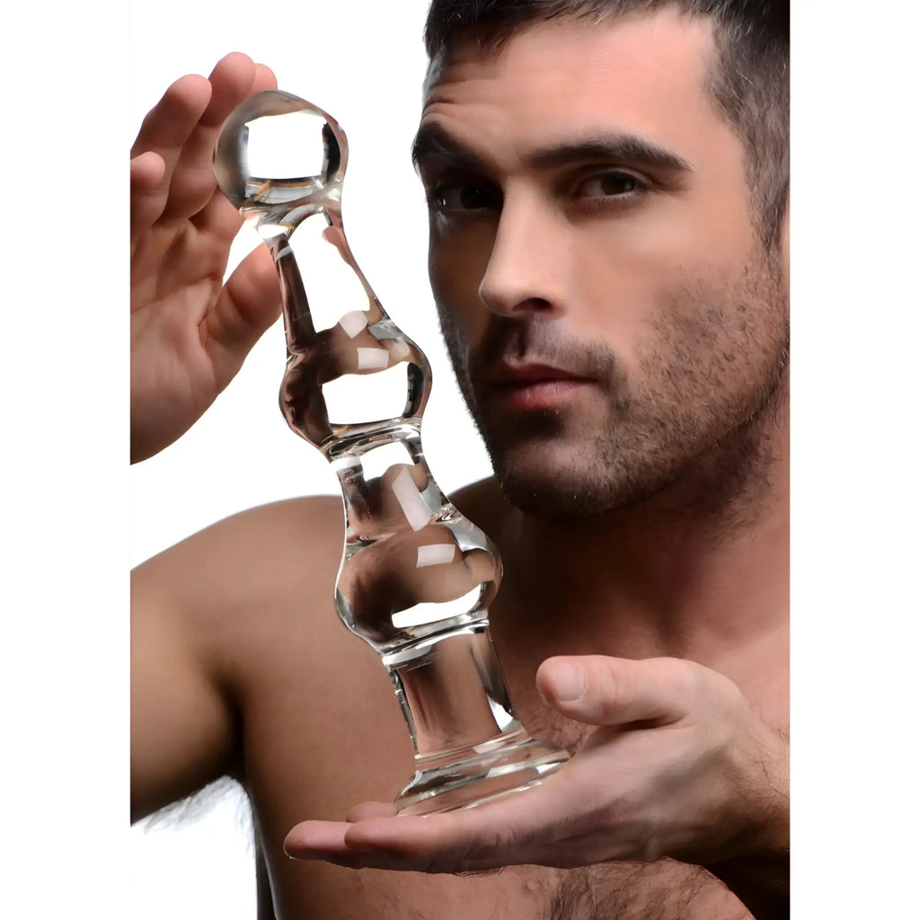 Man holding a clear, multi-bulb Master Series Mammoth glass dildo with a fluted base.