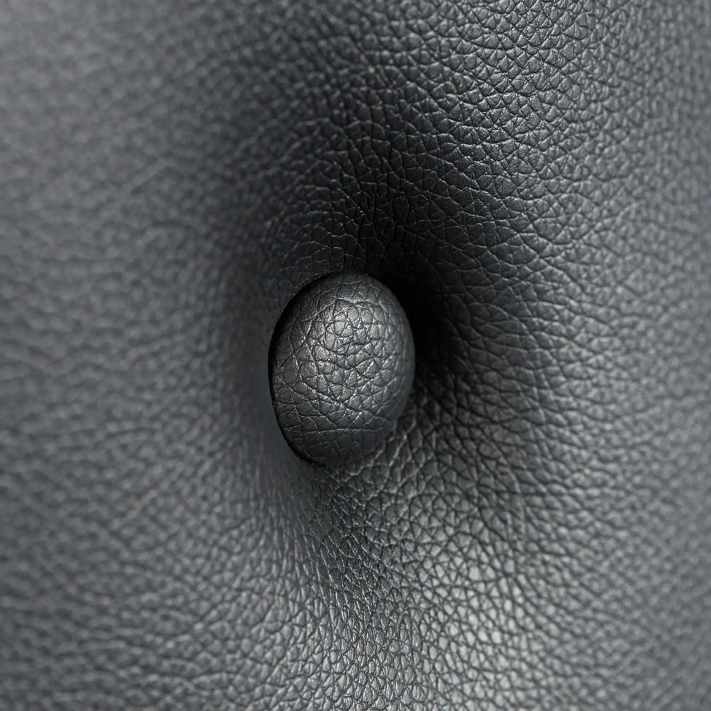 Close-up of black, textured faux leather on the Master Series Masters St. Andrew's Cross with a button-tufted detail.
