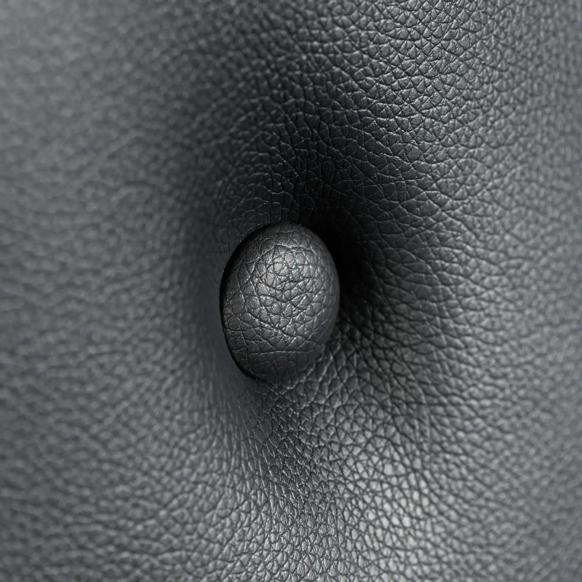 Close-up of black, textured faux leather on the Master Series Masters St. Andrew's Cross with a button-tufted detail.