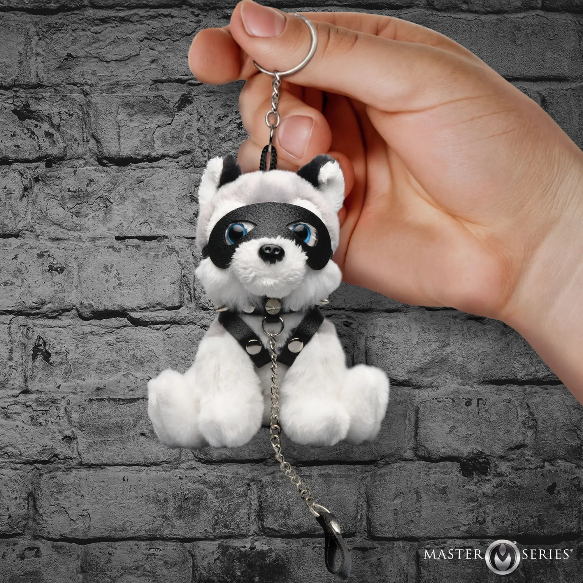 Master Series Max the Fetish Pup plush keychain with black leather mask, studded collar, and harness on brick background.