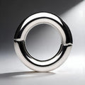 Master Series Mega Magnetize: A polished, silver-colored stainless steel magnetic cock ring in a circular design.