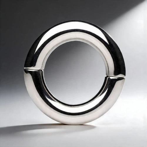 Master Series Mega Magnetize: A polished, silver-colored stainless steel magnetic cock ring in a circular design.