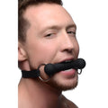 Master Series Mr Ed lockable black silicone bit gag worn by a man, featuring a black bar and a black strap.