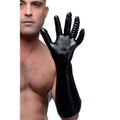 A man wears a black Master Series MS Pleasure Fister textured glove with ridged fingers and a long, ribbed forearm.