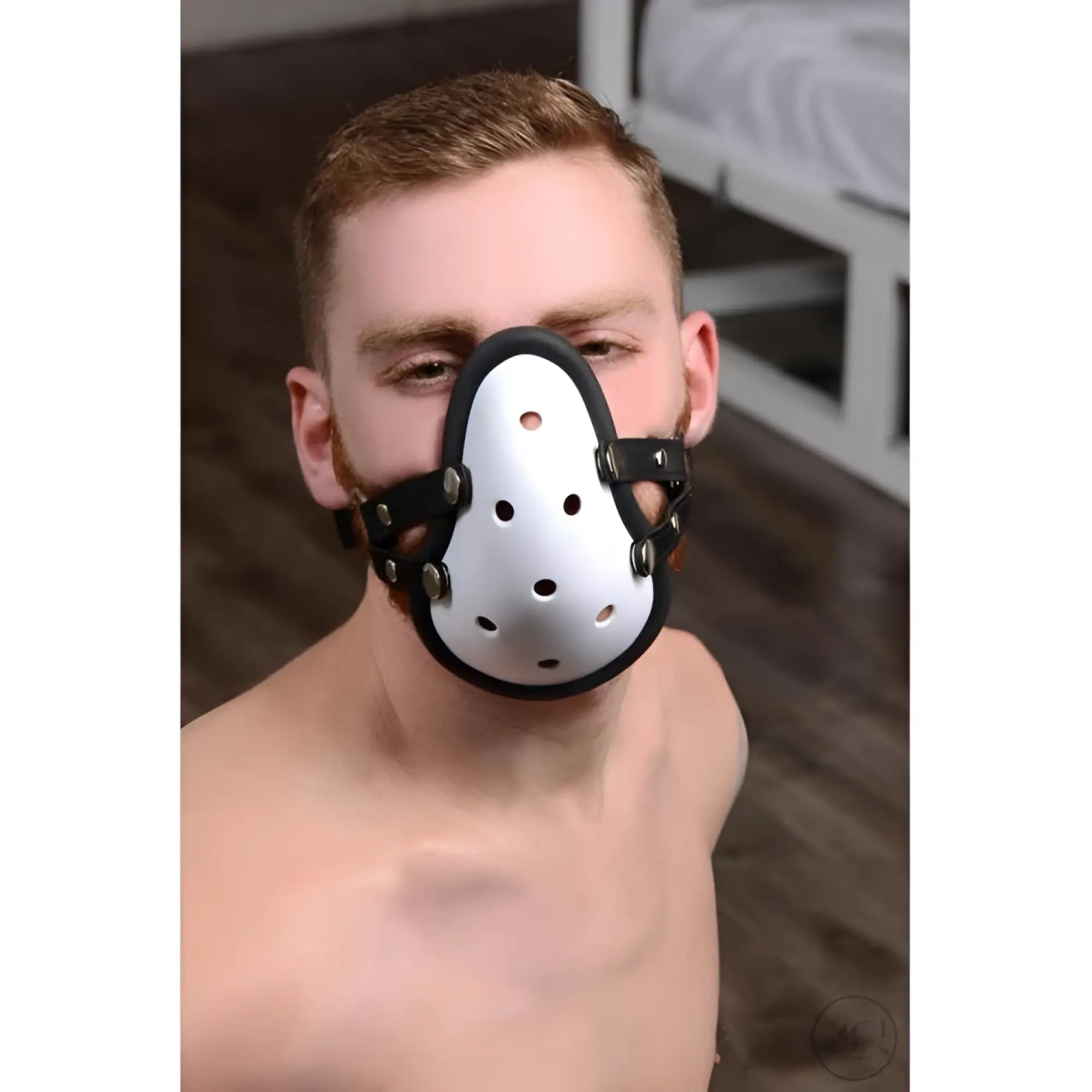 A man wearing a white, vented Master Series Musk Athletic Cup Muzzle with black leather straps and silver hardware.