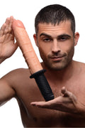A man holding a Master Series Onslaught XL dildo with a realistic skin-toned textured shaft and black ribbed base.