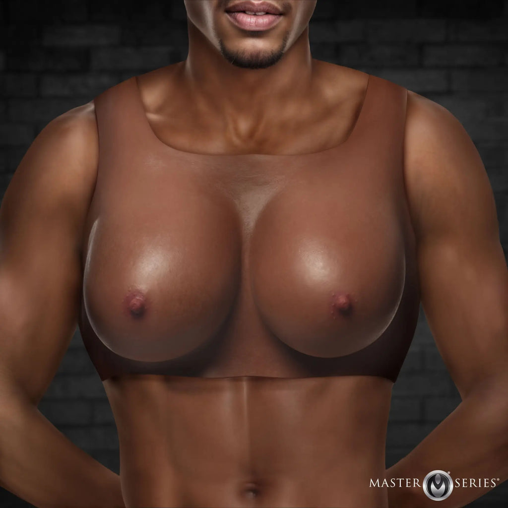 Master Series Perky Pair dark silicone breast form worn on a dark-skinned model against a dark brick background.