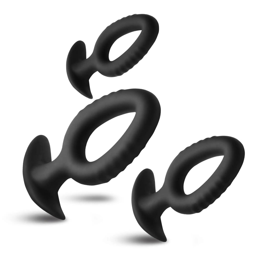 Three black, hollow silicone Master Series Pop Plugs in different sizes, featuring ring shapes and wide flared bases.