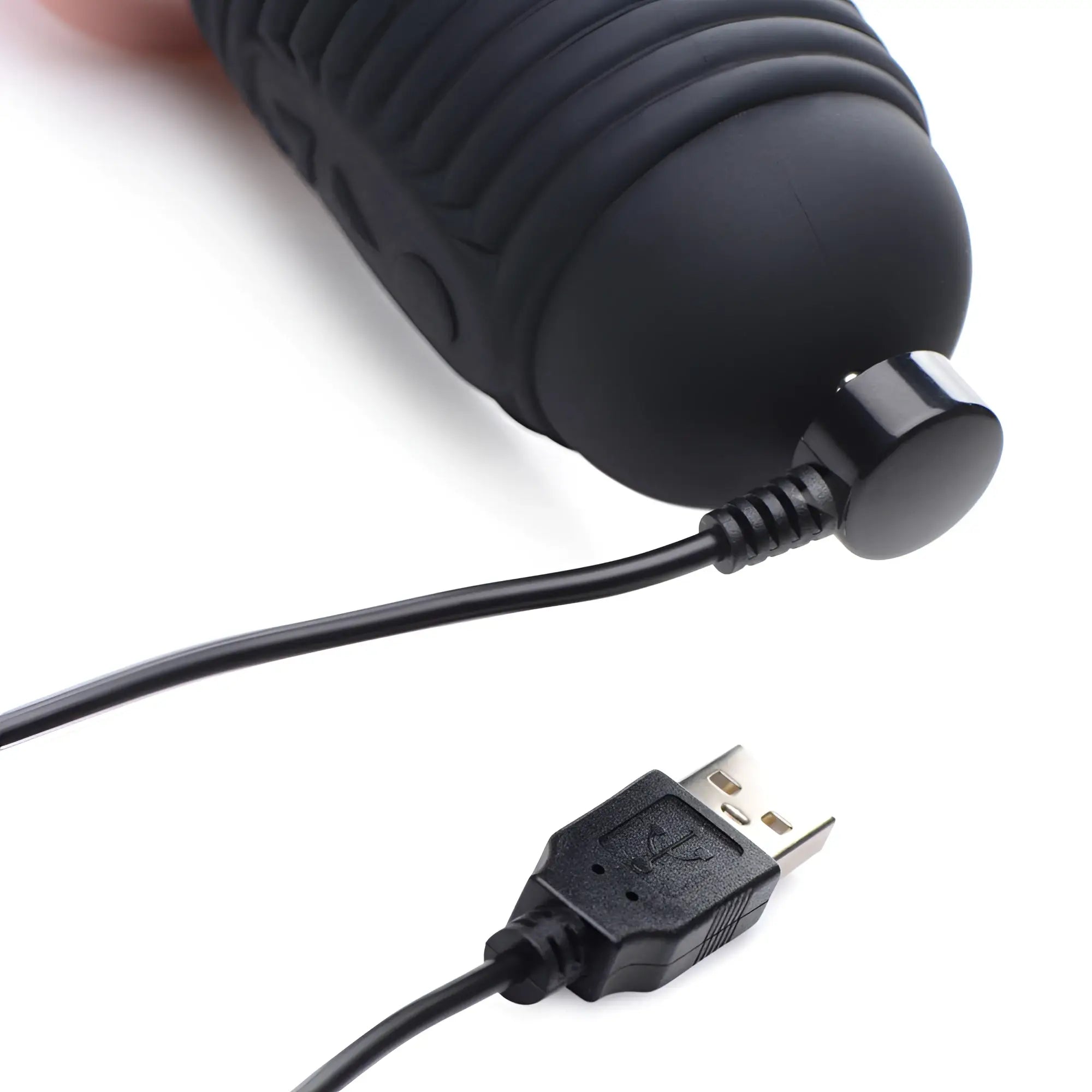Master Series Power Pounder silicone dildo in black with a ribbed texture, shown attached to its magnetic USB charger.